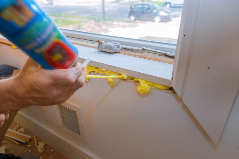 Man putting insulation foam around a window