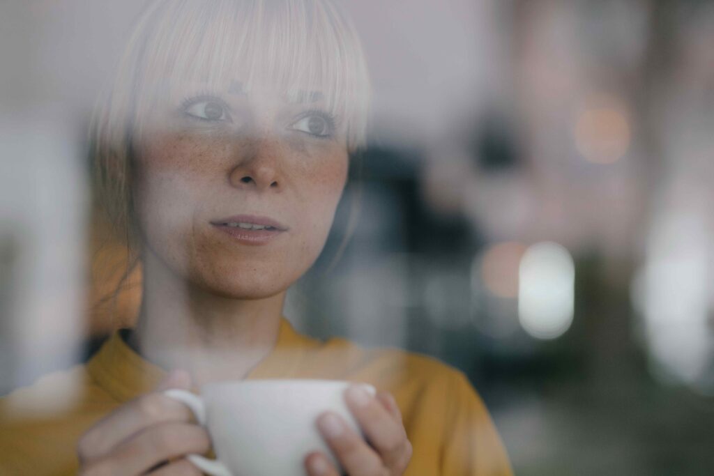 Woman standing in front of window holding a mug