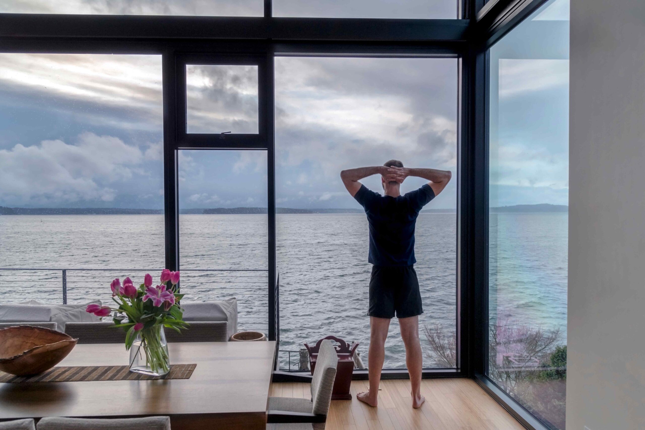 Man standing in front of large windows