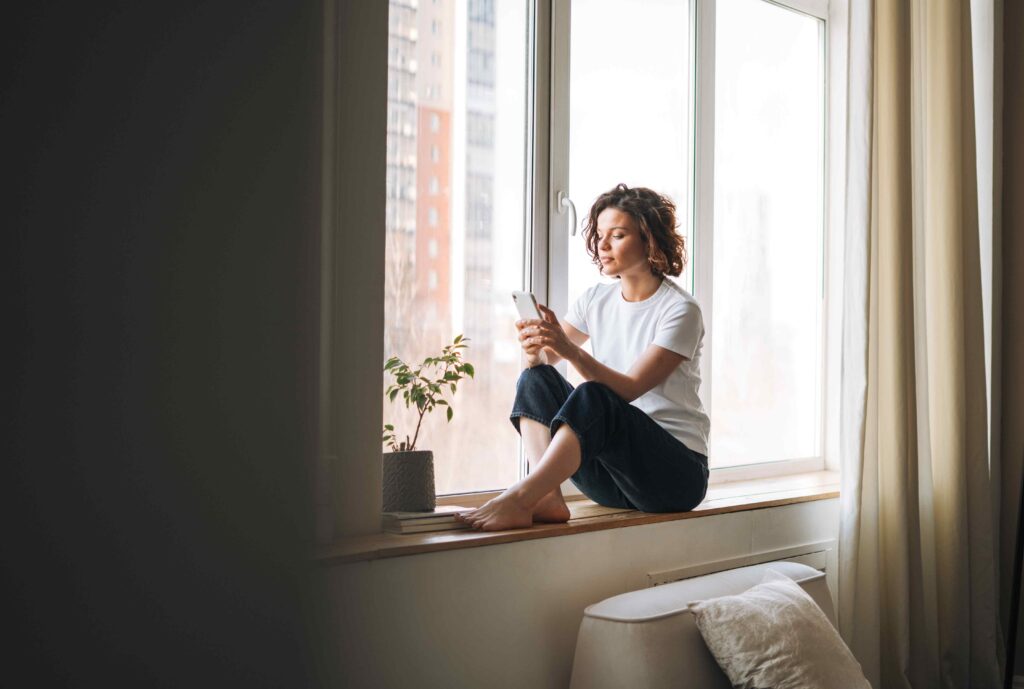 Woman sitting in front of large sliding windows