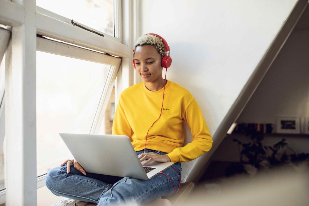 Woman in front of window, on her laptop